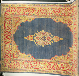 Carpet with central medallion in an indigo field framed by cusped spandrels and red leafy floral vine borders, Indian, from Amritsar