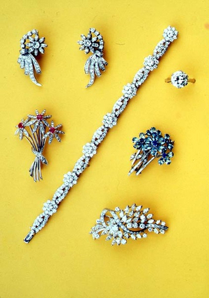 Selection of diamond spray brooches; diamond cluster flower bracelet; diamond solitaire ring; flowerhead diamond earrings