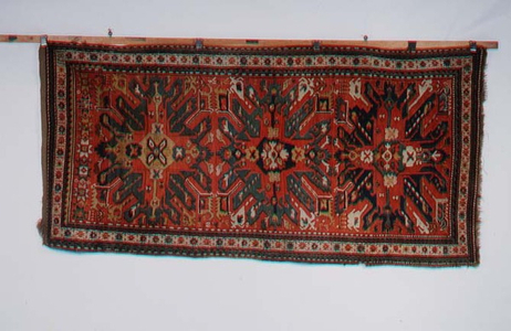 Chelaberd Rug, the madder field decorated with tribal and zoomorphic devices around three sunburst medallions enclosed by narrow stellar motif ivory borders and saw-tooth guard stripes, 1893