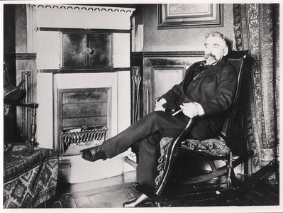Stephane Mallarme (1842-98) seated by the fireplace at his home on Rue de Rome, Paris (b/w photo)