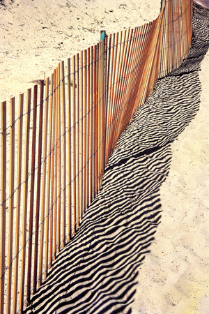 Fence reflection on sand (photo)