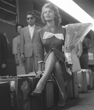 Italian actress Sophia Loren sitting on her suitcases on the track at the railway station, Venice, 1955 : Sitting On Her Suitcases