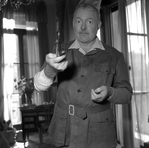 American writer Ernest Hemingway, wearing a short sleeves shirt over a plaid shirt, his hurted arm bendaged, holding an African sword in his right hand, Venice 1954