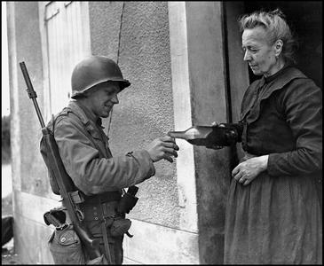 Second World War (1939-1945): an old woman, the only remaining resident in Marigny, offers a glass of cider to an American GI's. Marigny, Manche, France, July 29, 1944. Photography.