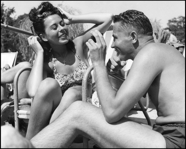 Second World War (1939-1945): at the Racing Club de France, an American officer holds a pocket mirror to a young Parisian woman by the pool. Paris, 24 June 1945. Photography.