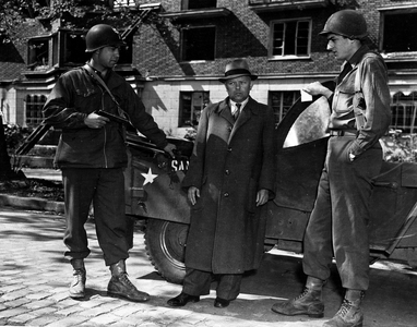 WWII:Dusseldorf (Germany) at the end of April 1945: A lieutenant and a sergeant of the 1st US Army have just stopped a notable of the NSDAP Willi Schmidt who was looking for atrocities against Jews