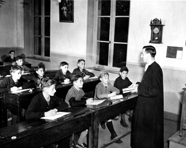 Vouziers (France) October 2, 1944: When the school reopened in the city liberated by Allied troops, the children of the last year of the communal school listen to their master, a Franciscan father.