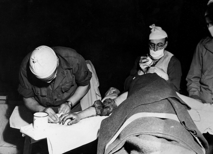 WWII:Region of Saint-Nazaire France January 1945: In a US Army field hospital, a military surgeon learns to amputation the right arm of a GI's hit by shells.