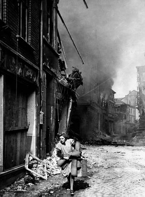 WWII:Siegburg (Germany) around 10 April 1945: Carrying on her meagre business, this woman fled the burning buildings just after the 97th US DI took over the city