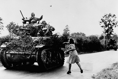 WWII:Saint-Pois (Manche) France around 7 August 1944: A young Frenchwoman throws flowers at the crew of a light M5 Stuart tank of the 4th DB US near the city