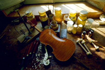 Cremone 1987. Atelier de lutherie: production de violons. Detail d'un violon en cours d'elaboration et des différents outils utilisés par les luthiers (vernis...) Photo Oliosi 