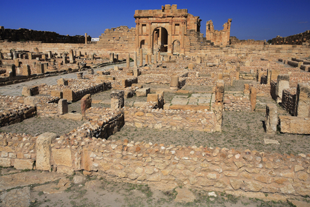 Series of houses and shops from the Roman era, Antoninian arch and capitol in the background/Sufetula (Sbeitla)/Tunisia