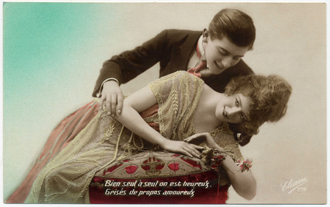 A couple of lovers, the woman leaning on a cushion, the man leans over her tenderly Postcard of the 1920s