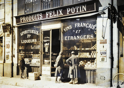 Two French soldiers and a boy in front of the liquor store Felix Potin at the market, Reims, Marne, France, 1917 (autochrome)