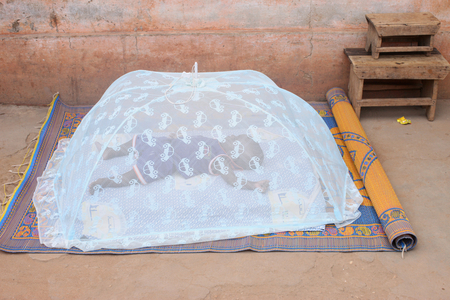 Baby sleeping under a mosquito net, Lome, Togo