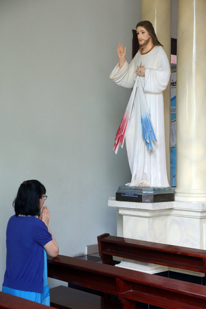 Ho Chi Minh city. St Philip church ( Huyen Sy Church ). Woamn praying Christ. Ho chi Minh City. Vietnam