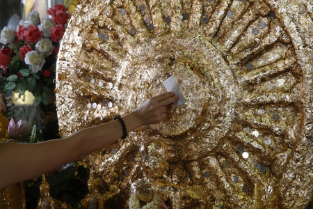 Faithful offering gold leaves in Wat Mahathat, Phetchaburi. Thailand