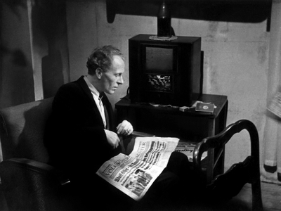Nazi Germany: Man reading the newspaper “Voelkischen Beobachter” of the N.S.D.A.P. (Nationalsozialistische Deutsche Arbeiterpartei), a German political party with extreme right. Photography around 1938.