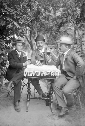 Three gentlemen drinking wine. Photography around 1915