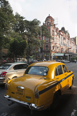 Transportation; yellow Ambassador taxi; old British colonial architecture; Chowringhee; Kolkata; West Bengal; India; South Asia; Asia