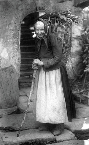 Farmer's wife carrying bundles of wood in a hood.