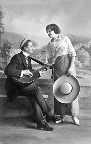 Love scene: Man playing music for a woman. Photography around 1916