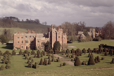 Exterior showing topiary garden and church beyond, Compton Wynyates, Warwickshire, late 15th-early 16th century (photo)