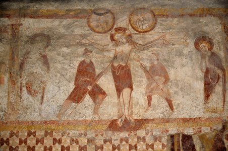 Romanesque art: Central view of the frescoes of the nave of the church Saint Laurent (St. Lawrence, 12th-13th century) of Lourouer-Saint-Laurent (Lourouer Saint Laurent), Indre (36100), Centre. France. Wall paintings on the walls of the nave and the choir, dating from the 12th and 13th centuries for the historical parts, and from the 15th century for the geometric motifs. Crucifixion, the spear by Centurion Longinus. John collects the blood of Jesus Christ in a vial