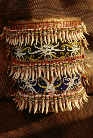 Baby carrier with a beaded masks motif and three rows of leopard's fangs from Sarawak, Malaysia (mixed media)