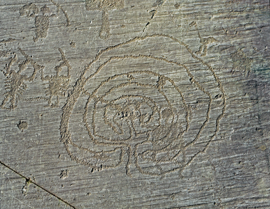 Representation of warriors weapons of shields and swords, and a maze.(engraved rock)