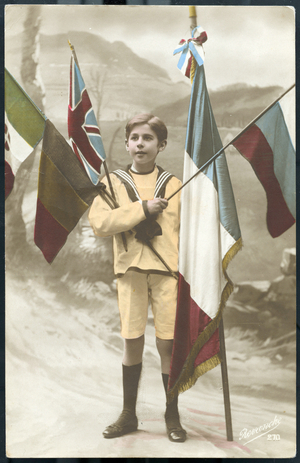 First World War: France, A young child poses with the five flags of allied countries in a bucolic landscape, 1915