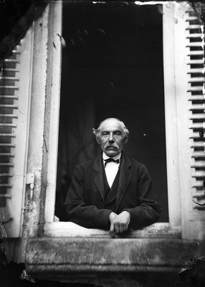 Germany: Mr Nau traveling, in the window of his house, 1865