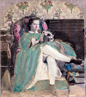 Portrait of a young girl sitting on an armchair looking at a bag, 1865