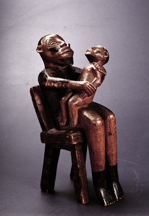 Seated father figure holding a child, Bembe, Congo, early 20th century (wood)