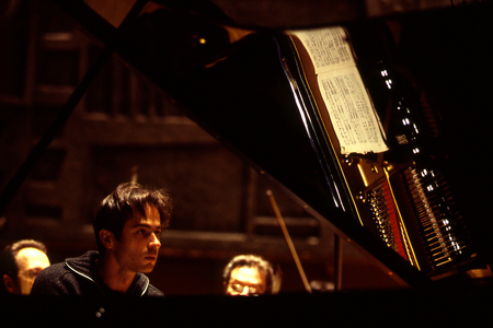 Piotr Anderszewski - portrait of the Polish pianist, b. 1969. Score reflected on piano's lid. Reflection