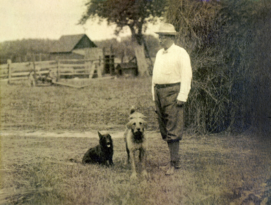 Theodore Roosevelt (1858-1919) President of the United States of America (USA, 1901 to 1909) with two dogs around 1905 - Theodore Roosevelt standing with two dogs next to haystack c1905 -