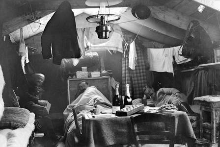 First World War 1914-1918 (14-18): three French soldiers (hairy) layers inside their “cagna” (makeshift shelter in the trench, made of recuperation materials) - a play of checkers, books and victuals (bottles of sparkling wine and dry cakes) sent by the families of the fighters - trench - front - negative photographic anonymous, private collection - see similar view: GUT6662 -