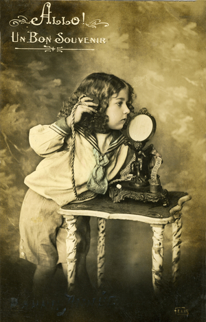 Postcard fantasy around 1900: boy calling. The phone is a special model: this device decorated with an angelot comes from a brothel!