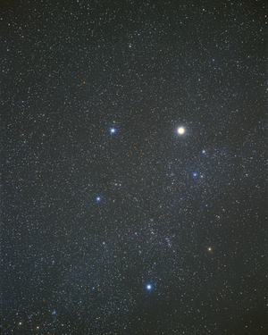 Constellation Constellation of Auriga - The brightest star in the constellation is Capella. Auriga (the Charioteer) is one of 48 constellations (out of the current 88) that were noted by Ptolemy (83 - 161 CE). It represents a chariot and its driver, a shepherd, with a goat or a sheep over his shoulder. The brightest star in Auriga is Capella, which is the ancient Greek word for little goat. It is a binary star 42 light years distant and is about 75 times more luminous than the Sun. Surprisingly, Capella is one of only two conspicuous stars whose combined light is similar to that of the Sun (the other is Alpha Centauri), so appears white on this photograph. Sun - like stars are common but are generally too faint to be seen at a distance which is why there are so few visible to the eye. Best seen in the early evening in February