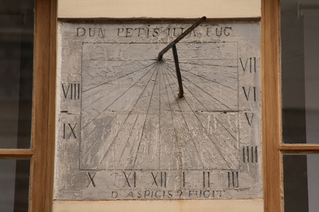 Sundial - Rue de Lille - Paris - Sundial in Paris - Rue de Lille: At 14 de la rue de Lille (75007), there are the remains of a mansion dating from the end of the 18th century whose door is surmounted by a vertical sundial declinating the afternoon. It bears the inscriptions: “Dum petis illa fugit” at the top and “Quid aspicis fugit” at the bottom. The first phrase means “” While you're looking, the hour flies,” the second “” What are you waiting for? She's running away. This dial has been restored