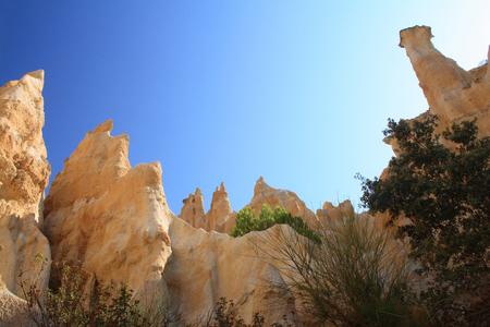 Organs of Ille - sur - Tet - Pyrenees - Oriental - France - Columns of clay 30 meters high, sculpted by wind and rain. These columns are also known as “” cheminees des fees”” or “” bridesmaids””. Pyrenees - Orientales. Orgues d'Ille - sur - Tet is a geological site in the Pyrenees Orientales. The organ pipes are rock formations produced by several million years of geological history; these natural chimneys are made of columns of soft rock eroded by wind and rain overhung by harder rock