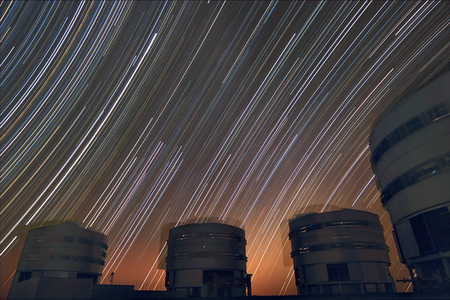 Star trails over VLT - Star trails over VLT - Star file on Celestial Ecuador. Near the horizon, the moving domes of the Very Large Telescope. Star trails on the celestial equator. Below are the Very Large Telescope domes rotating