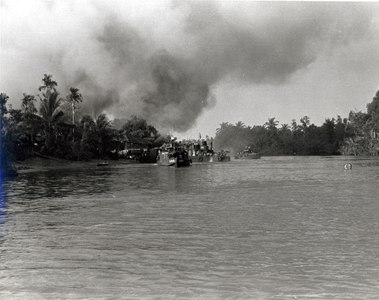 Smoke rises from a Viet Cong propaganda centre and two VC tax collection stations following a US Navy SEAL search and destroy operation, 25 January 1968 (b/w photo)