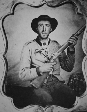 Unknown Confederate soldier posing in photographer's studio (b/w photo)