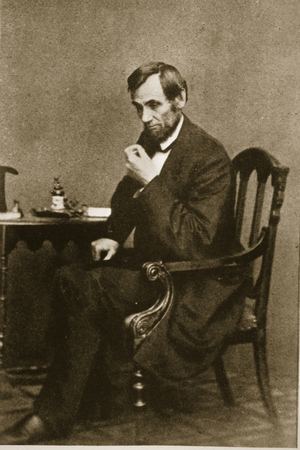 Abraham Lincoln sitting at a desk in the Washington Gallery, May 1861 (b/w photo)
