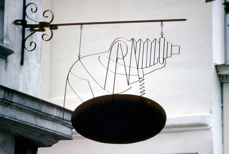 Photographer silhouette leans on the photographic chamber, made of wire, trade sign in Paris.