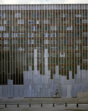 Facade of the Grenier du Lieu Unique in Nantes. Architecture by Patrick Bouchain, 2000. Photography 2000. The attic is made up of a glazed facade on the street behind which there are containers inside which are preserved objects symbolizing the twentieth century. Inside the building a wall of parpaings encloses the window and cannot be dismanned until the end of the 21st century.