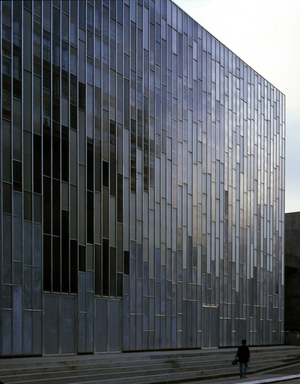 Facade of the Grenier du Lieu Unique in Nantes. Architecture by Patrick Bouchain, 2000. Photography 2000. The attic is made up of a glazed facade on the street behind which there are containers inside which are preserved objects symbolizing the twentieth century. Inside the building a wall of parpaings encloses the window and cannot be dismanned until the end of the 21st century.