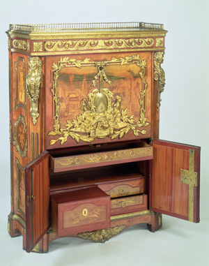 F299 Louis XVI drop-front secretaire, with pictorial marquetry of classical ruins and floral emblems, gilt bronze mounts and carrara marble top, by Antoine Foulet (d.1775) (mixed media)