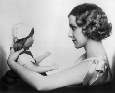 Vienna, Austria: c. 1926
Continental film star and actress Hanni Hoessrich gazes at a doll in her hands.